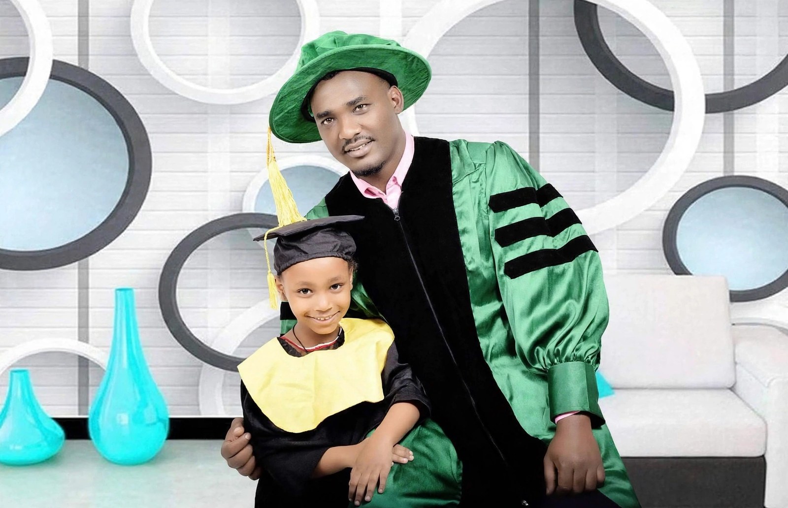 Prof. Nebiyu Lera Alaro in his graduation gown with his daughter in her kindergarten graduation cap and gown